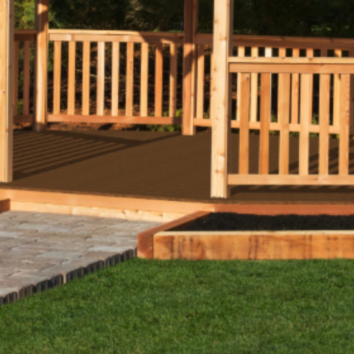 A close-up shot of a wooden gazebo railing with a dark brown floor, showing a stone pathway and green grass in the foreground.