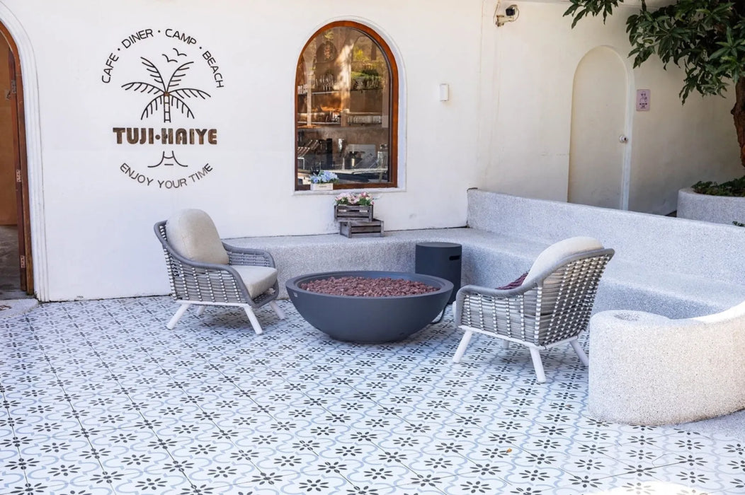 Outdoor seating area with a fire pit and chairs, featuring the TUI-HAVRE logo on the wall.