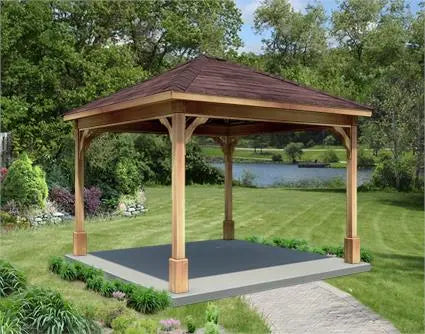 12ft x 12ft cedar wood ramada structure with a gabled roof and a concrete base. The ramada is surrounded by lush greenery and a lake is visible in the background.