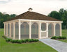 A large, rectangular screened gazebo with a peaked roof and decorative latticework. The gazebo has a double door with a small window and is surrounded by lush greenery.