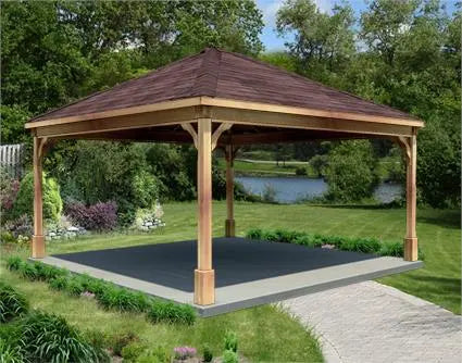 14ft x 14ft cedar wood ramada structure with a gabled roof and a concrete base. The ramada is surrounded by lush greenery and a lake is visible in the background.