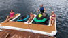 People on a floating platform with watercraft in the water
