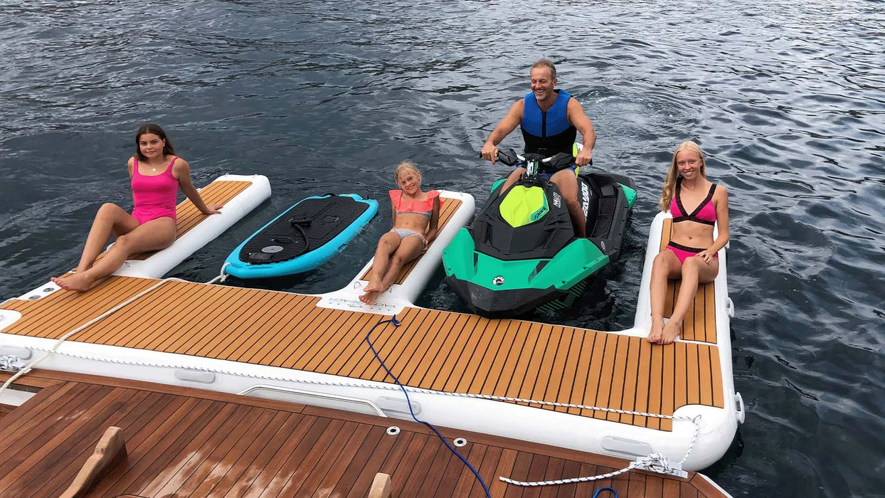 People on a floating platform with watercraft in the water