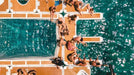 People sunbathing on a floating platform over turquoise water
