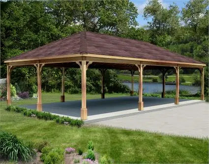 16ft x 16ft cedar wood ramada structure with a gabled roof and a concrete base. The ramada is surrounded by lush greenery and a lake is visible in the background.