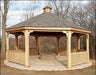 A large octagonal wooden gazebo with a shingled roof, decorative cupola, and lattice railings. A brick fire pit is centered in the gazebo's floor.