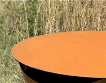 A round, orange fire pit lid placed on top of a black fire pit.