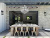 A close-up of two electric patio heaters mounted on a brick wall beneath a crystal chandelier. The heaters add warmth and ambiance to an outdoor living space.