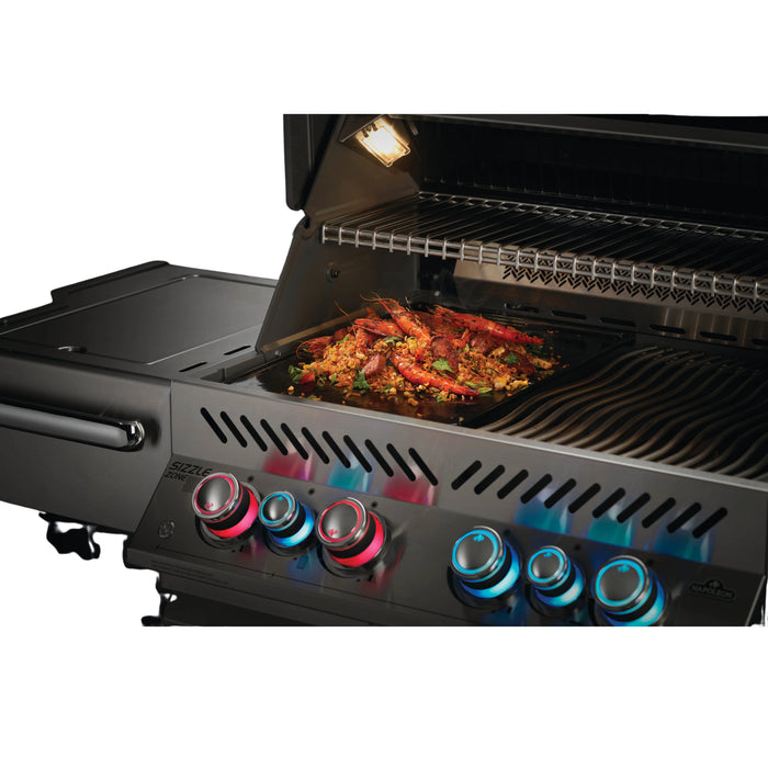 The Napoleon gas grill with reversible griddle lets you easily switch between grilling and stovetop cooking. It's shown cooking delicious shrimp."