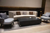 A rectangular black marble porcelain coffee table with cups on it in a living room setting.