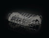 A stainless steel rib rack with multiple curved slots to hold individual ribs. The rack is resting on a reflective black surface, creating a dramatic effect.