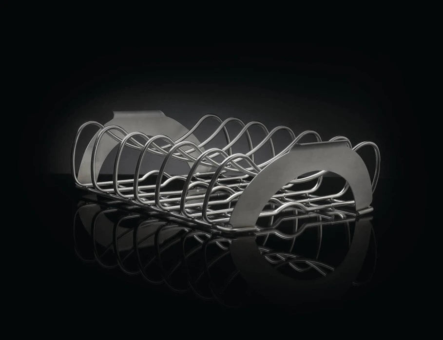 A stainless steel rib rack with multiple curved slots to hold individual ribs. The rack is resting on a reflective black surface, creating a dramatic effect.