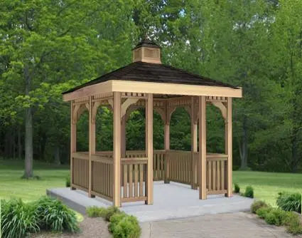 A large, rectangular cedar gazebo with a double roof and decorative cupola. The gazebo features intricate latticework details and a spacious interior.