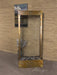A free standing water fountain, a beautiful adagio water feature. The "Harmony River," features a wide, textured glass panel where water gently cascades down into a shallow basin filled with smooth, grey river stones. 