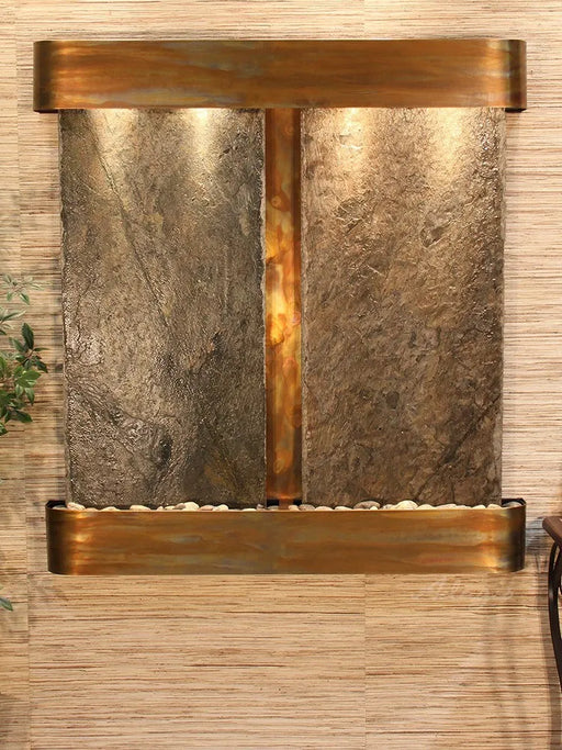 Here are a few options for an alt description of the Adagio Aspen Falls Wall Water Fountain image:

Option 1 (Descriptive):

A wall-mounted Adagio Aspen Falls water fountain featuring two textured slate panels with water cascading down their surfaces. The fountain is framed by a warm-toned metallic structure, likely copper or bronze, with lights illuminating the slate from the top. 