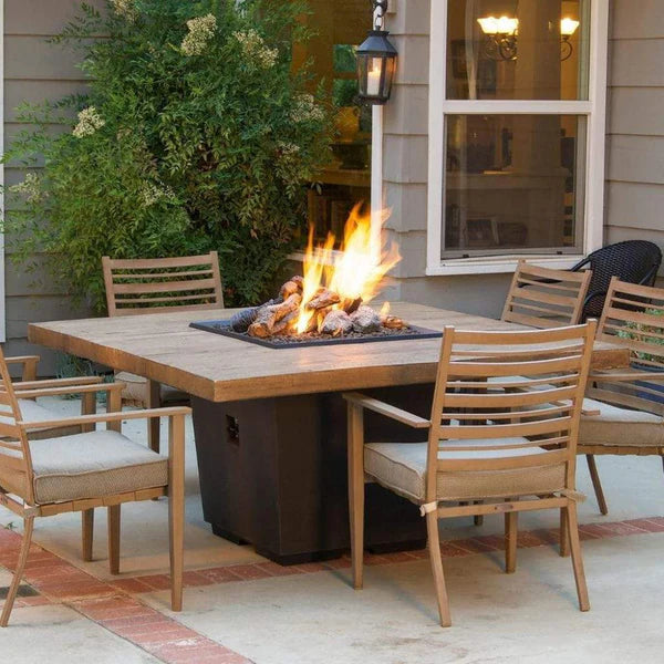 A cozy outdoor dining scene with a fire pit table taking center stage. The warm flames create a welcoming ambiance as chairs are arranged around the table, ready for a gathering.