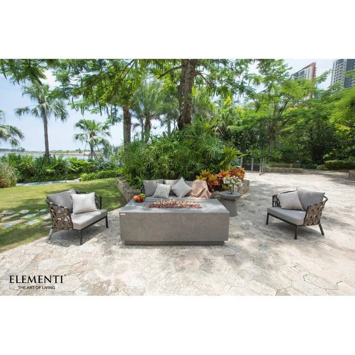 Modern rectangular Elementi Andes fire table with a concrete look, surrounded by cushioned seating in an outdoor patio setting.