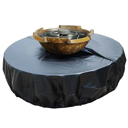 A round table with a black tablecloth. On the table is a black bowl.  The text on the side of the bowl is difficult to discern. In the background is a blurred image of fire pit covers . A black plastic cover on a round table with a white pillow on top. The text on the cover says "HPC Fire Pit Cover" and "Hpc Round Vinyl Fire Pit Cover 35".