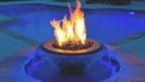 Black, round fire pit with a stainless steel fire bowl and water feature. Flames are visible in the center of the bowl, and water streams flow down the sides of the fire pit.