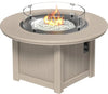 round fire pit table with a glass wind guard and a burning fire