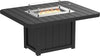 Square outdoor dining table made of weather-resistant black material with a built-in fire pit and glass wind guard.