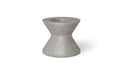 A sandstone, round poolside table with a wide base and a slightly tapered top.