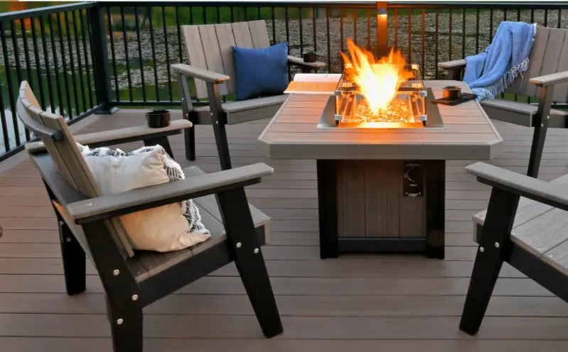 Outdoor patio setting with a fire pit table and chairs on a wooden deck.
