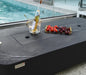 rectangular outdoor fire pit with lid. fruit platter and wine cooler on top of fire table