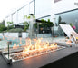 rectangle fire pit table with glass guard in outdoor setting beside the pool