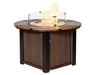  A round, wooden fire pit table with a black metal frame. The table has a glass wind guard and a flame burning inside.