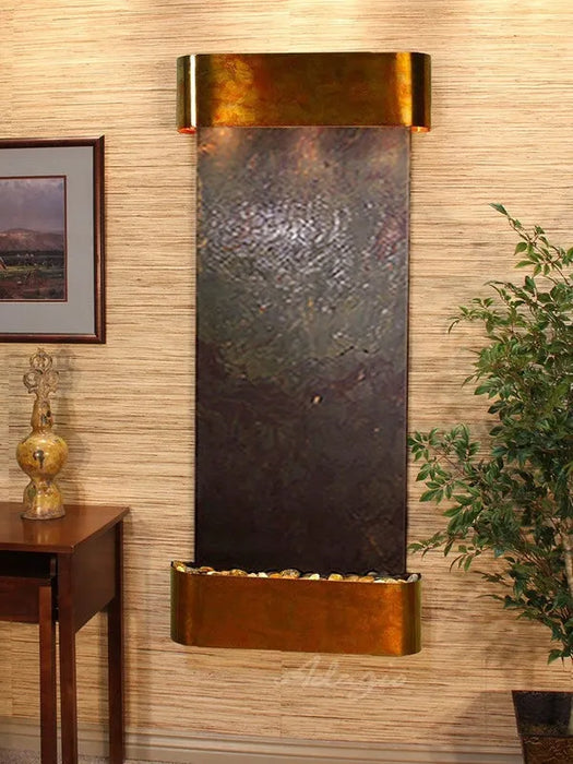 Wall-mounted water feature with bronze finish on a wall with decorative elements.