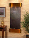 Wall-mounted water feature with bronze finish on a wall with decorative elements.