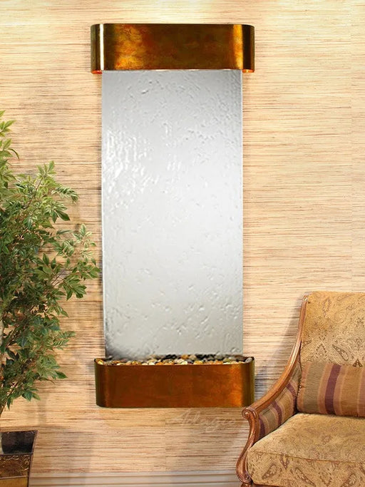 Decorative wall fountain with a plant and sofa in a room setting