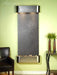 Wall-mounted water feature with dark stone finish and metallic frame against a light green wall.