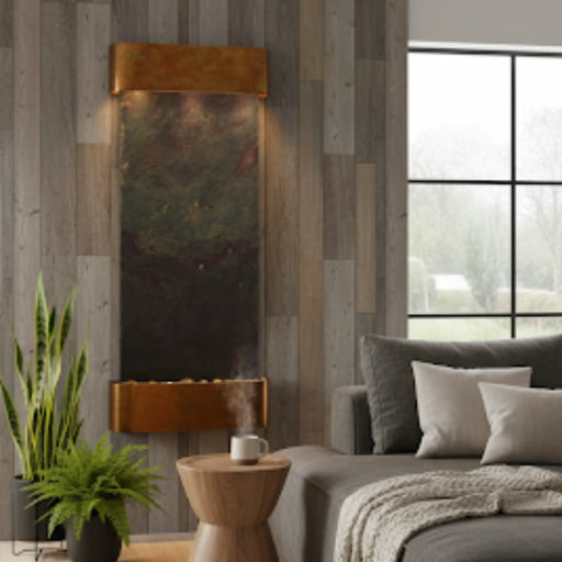 Living room with a indoor wall mounted water feature by adagio surrounded by plant, and sofa.