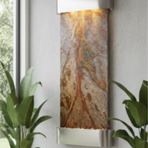 Decorative wall mounted indoor water fountain with a natural stone pattern on a white wall.