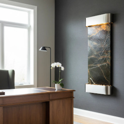Modern office interior with a wooden desk, decorative plant, and wall-mounted water feature by adagio