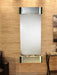 adagio Wall-mounted water feature with metallic finish on a wooden wall.