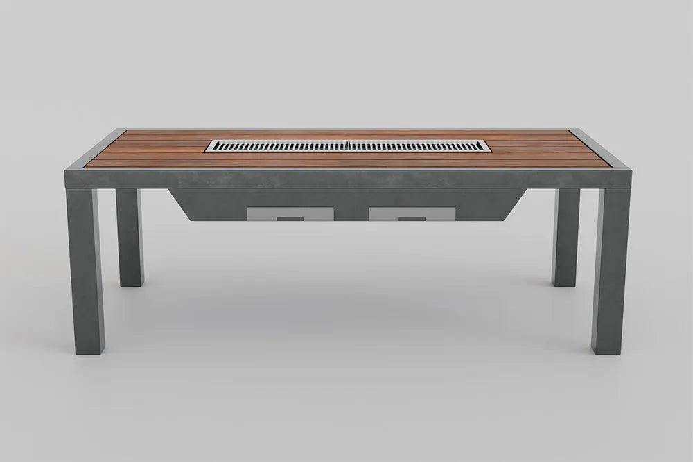 An angled front view of a bar-height outdoor grill table featuring a wood-slat top, a long built-in grill, and dark grey metal legs. A control panel with knobs is visible on the left side of the table, and two rectangular compartments are underneath.