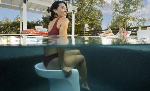 bar height in pool stool under the water with a lady sitting on the stool