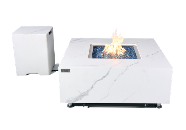 white marble fire table with black accents on marble. fire table uses blue fibre glass to light up fire. the fire pit is lit. it has a tank cover beside it. This fire table is from the brand Elementi Fires