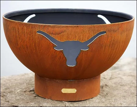  A round, rustic steel wood burning fire pit bowl with a longhorn cutout design. The fire pit is a deep brown color with visible rust.