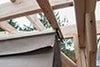 A wooden pergola with a gray cloth canopy partially extended.