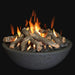 charcoal black fire pit bowl with lava rocks and fire pit logs inside fire pit. Fire pit is lit and yellow and orange flames are blowing