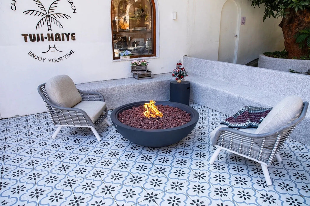 Outdoor seating area with a fire pit, chairs, and decorative elements on a patterned floor.