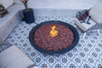 Fire pit with burning flames on a patterned patio