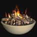 concrete fire pit bowl in bone share. lava rocks and fire pit logs are in the fire bowl and it is lit and letting out yellow and orange flames