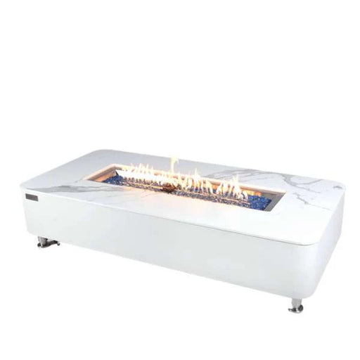 white rectangle fire pit table with a marble counter top. fire pit is lit on blue fire glass