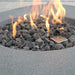 elementi boulder rock fire pit OFG110 high performance concrete with fire pit int he middle. flre table is lit on lava rocks in the middle and there is a steel burner next to it too