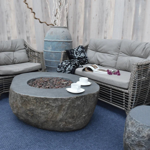 elementi boulder rock fire pit OFG110 with coffee cups on an outdoor patio